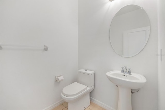 bathroom featuring tile patterned flooring, toilet, and baseboards