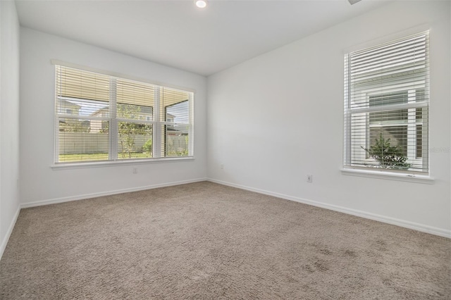 unfurnished room featuring carpet floors and baseboards