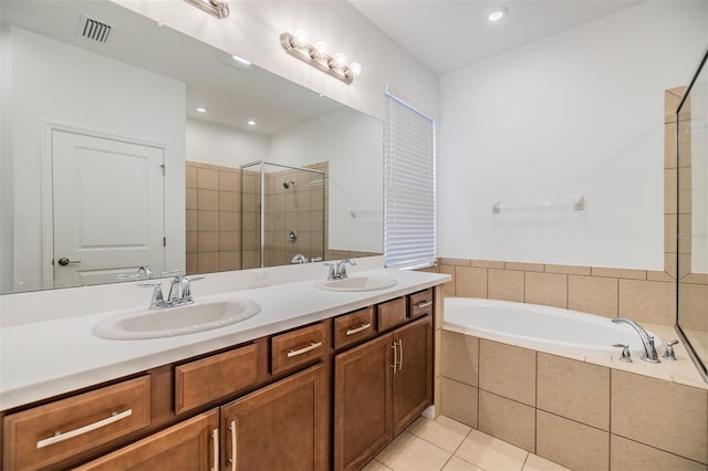 bathroom featuring a bath, a sink, visible vents, and tile patterned floors