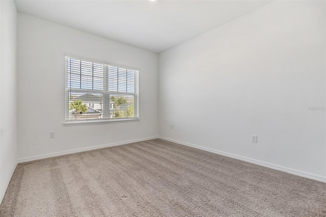 spare room with carpet and baseboards