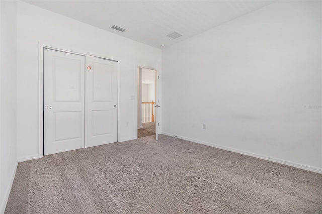 unfurnished bedroom featuring carpet, a closet, visible vents, and baseboards