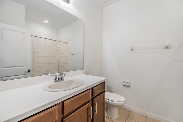 bathroom with tile patterned floors, toilet, vanity, baseboards, and walk in shower