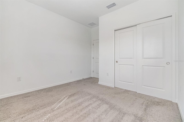 unfurnished bedroom featuring a closet, carpet, visible vents, and baseboards