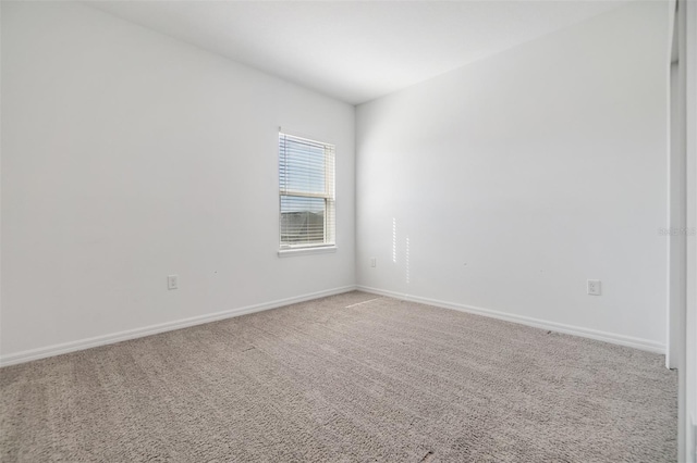 spare room with carpet and baseboards