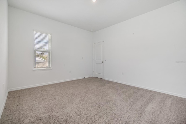 carpeted empty room with baseboards