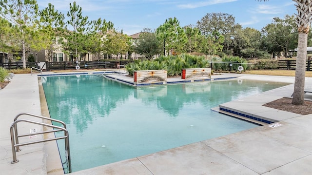 community pool featuring fence and a patio