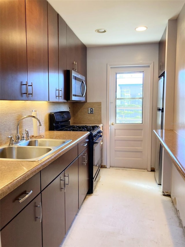 kitchen with a sink, tasteful backsplash, appliances with stainless steel finishes, and light countertops