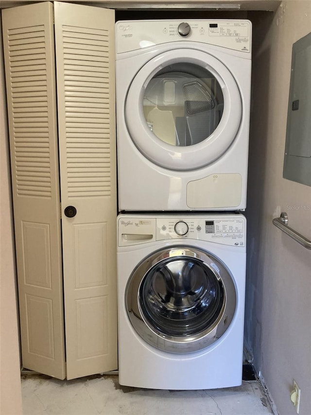 clothes washing area with laundry area, electric panel, marble finish floor, and stacked washing maching and dryer