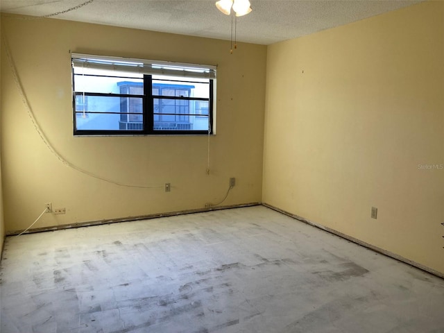 unfurnished room with a textured ceiling