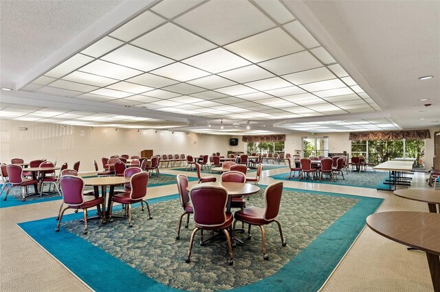 dining area with a drop ceiling and carpet floors