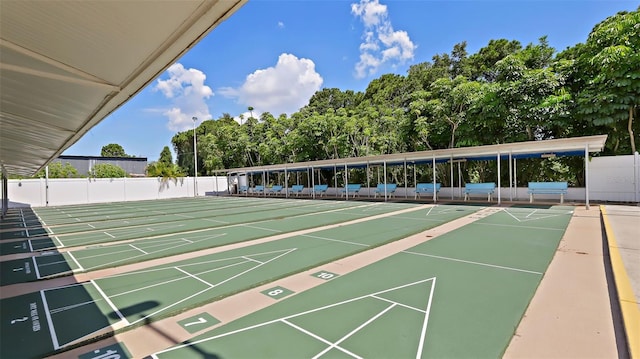 view of property's community featuring shuffleboard and fence