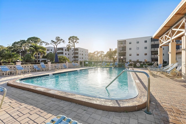 pool with a patio area and fence