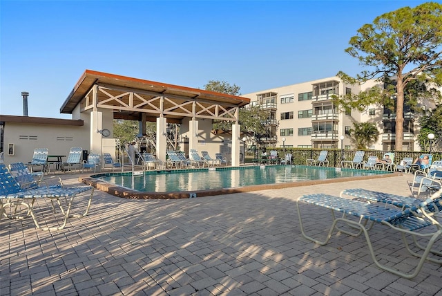 community pool with fence and a patio area