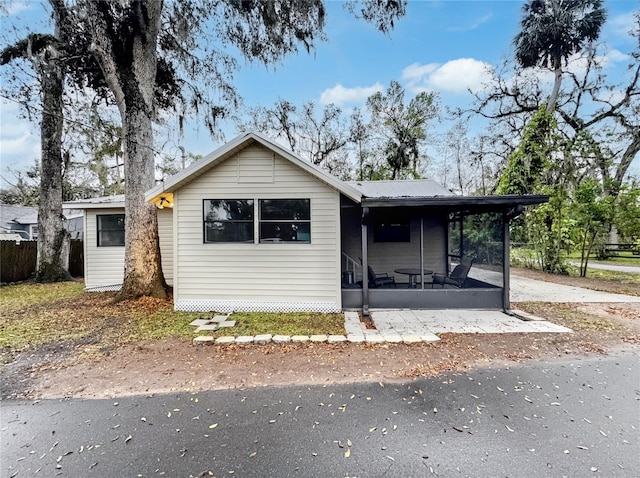 single story home with a sunroom and metal roof