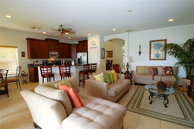 living area with arched walkways, visible vents, ceiling fan, and recessed lighting