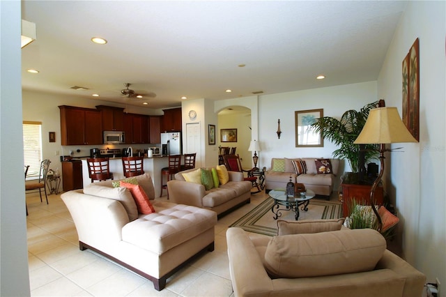 living room with light tile patterned floors, visible vents, arched walkways, a ceiling fan, and recessed lighting