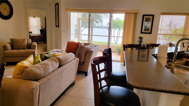 living area with a water view and light tile patterned flooring