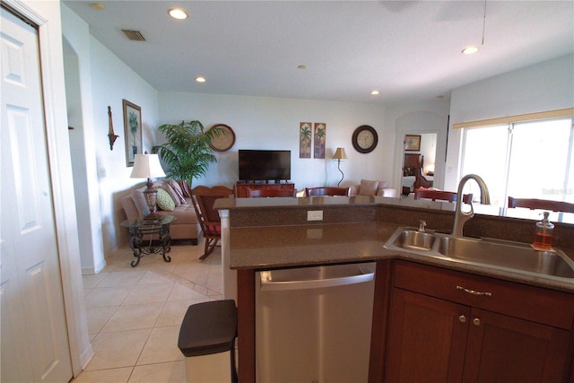 kitchen with light tile patterned floors, visible vents, open floor plan, stainless steel dishwasher, and a sink