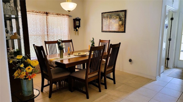 dining area featuring light tile patterned floors and baseboards