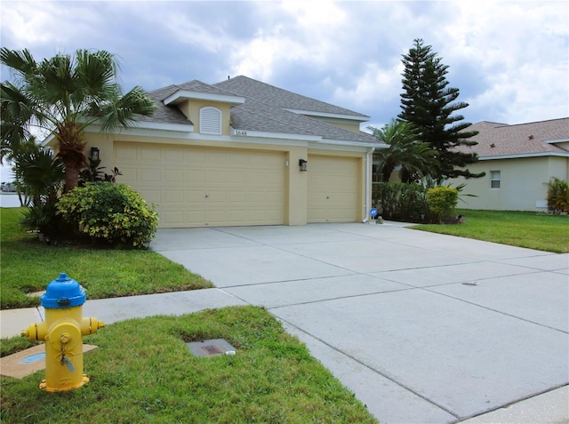 view of front of home with roof with shingles, stucco siding, concrete driveway, a garage, and a front lawn