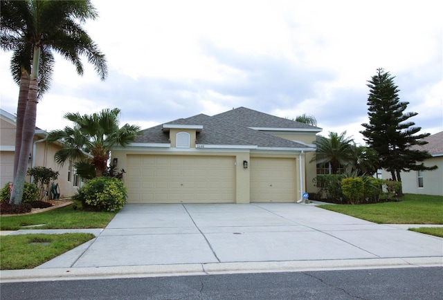 view of front facade with stucco siding, a shingled roof, a garage, driveway, and a front lawn