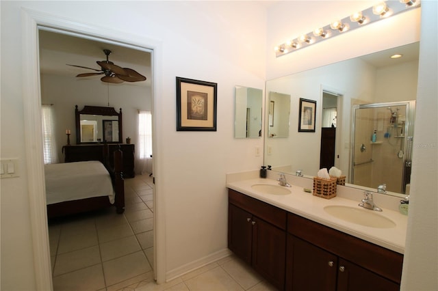 ensuite bathroom featuring tile patterned flooring, a shower stall, a ceiling fan, and a sink