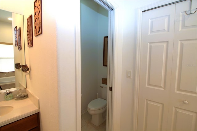 bathroom with toilet, tile patterned floors, and vanity