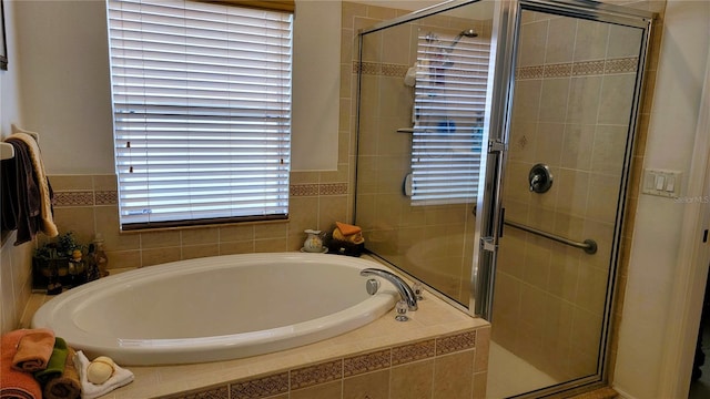 bathroom featuring a stall shower and a bath