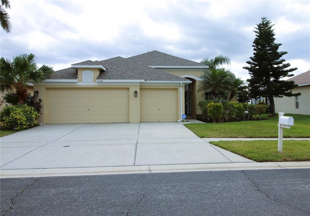 view of front of home featuring stucco siding, a shingled roof, concrete driveway, a garage, and a front lawn