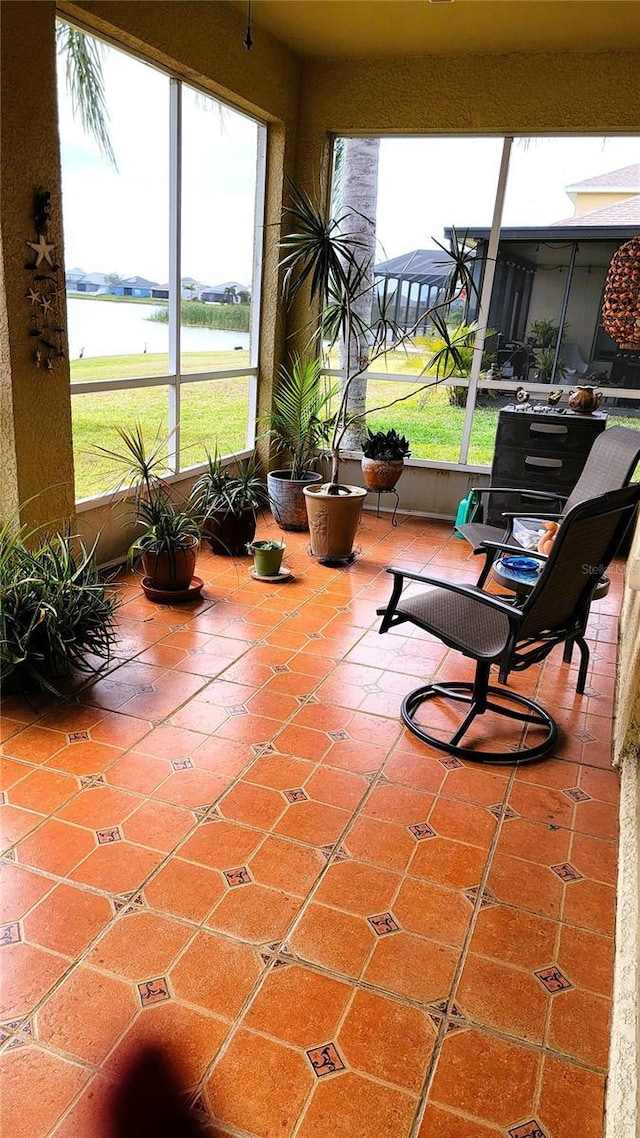 sunroom featuring a water view