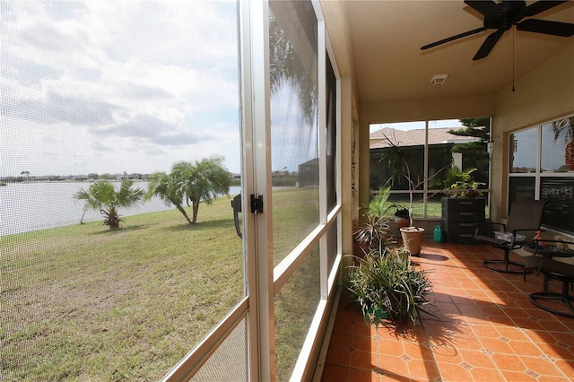 sunroom featuring a water view and ceiling fan