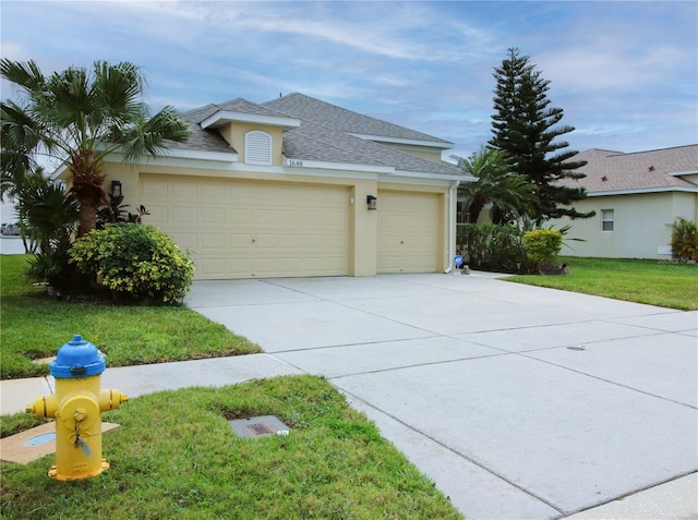 view of front of property featuring a garage, concrete driveway, roof with shingles, stucco siding, and a front lawn