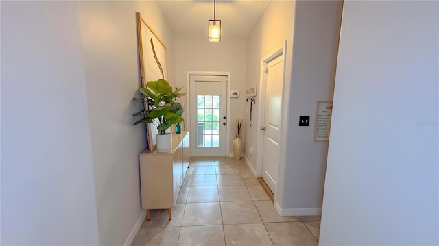 doorway to outside with light tile patterned floors and baseboards