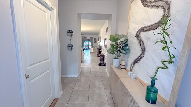 hallway featuring light tile patterned floors and baseboards