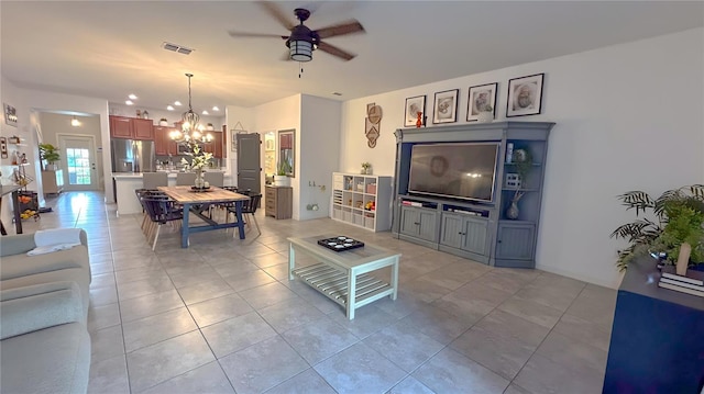 living room featuring ceiling fan with notable chandelier, light tile patterned flooring, and visible vents