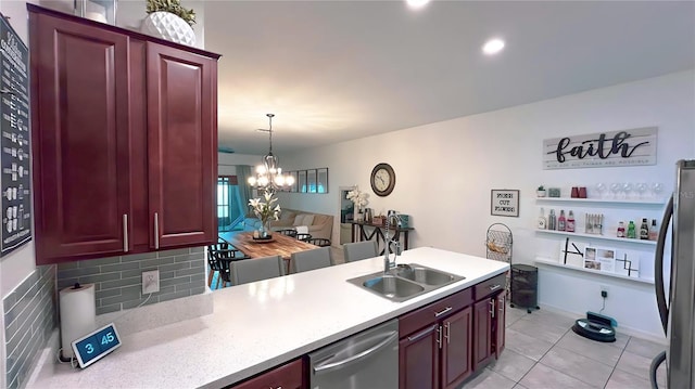 kitchen featuring reddish brown cabinets, stainless steel appliances, light countertops, hanging light fixtures, and a sink