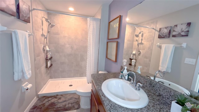 bathroom with toilet, a shower stall, and vanity