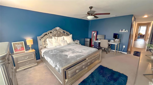 bedroom with a ceiling fan, freestanding refrigerator, light colored carpet, and visible vents