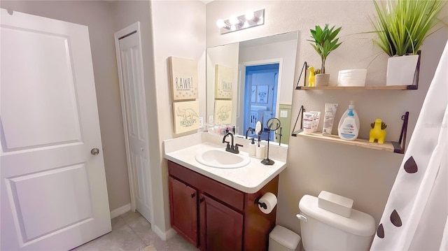 bathroom featuring a closet, vanity, toilet, and tile patterned floors