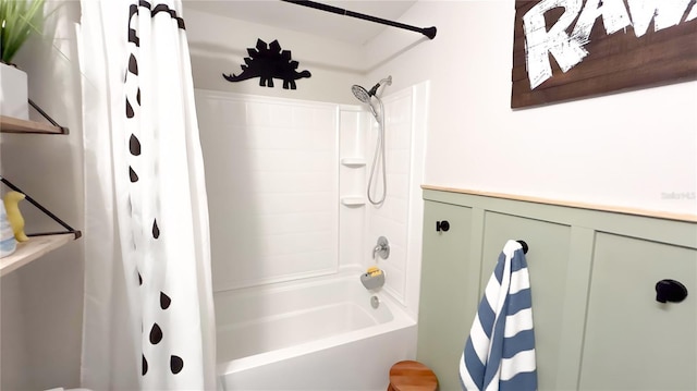 bathroom featuring shower / tub combo and a wainscoted wall