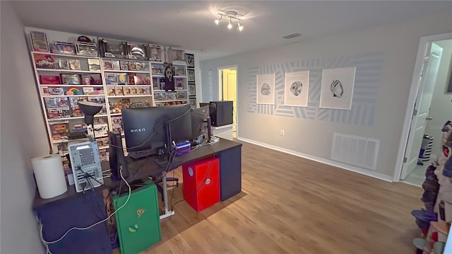 office space with wood finished floors, visible vents, and baseboards