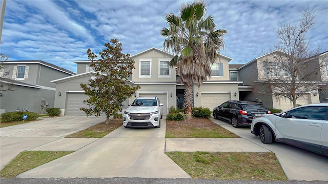 view of front of property with driveway, an attached garage, and stucco siding