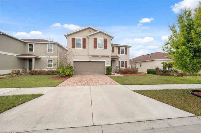 view of front of property featuring a front lawn, decorative driveway, an attached garage, and stucco siding