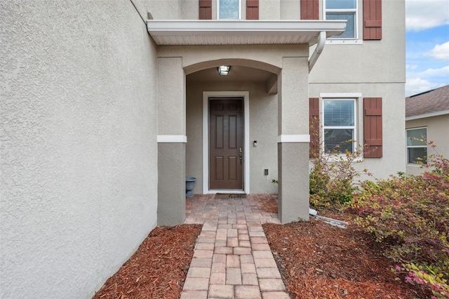 view of exterior entry featuring stucco siding