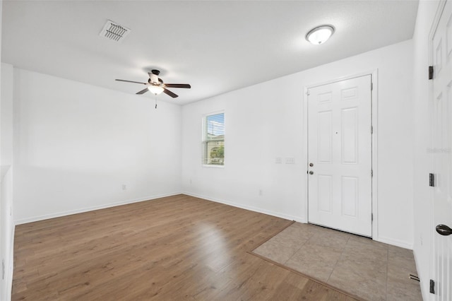 foyer with a ceiling fan, wood finished floors, visible vents, and baseboards