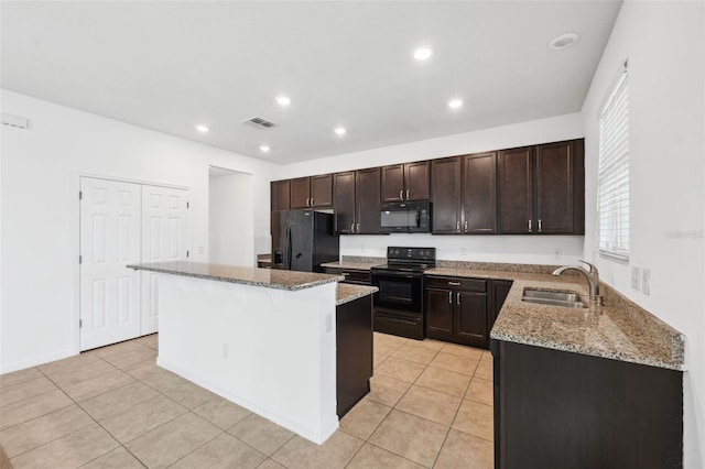 kitchen featuring a kitchen island, light stone counters, dark brown cabinets, black appliances, and a sink