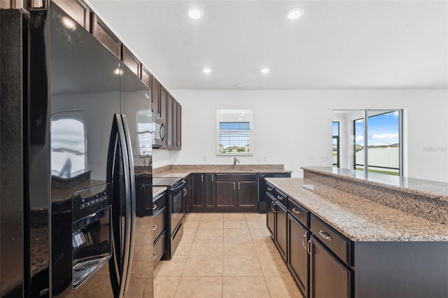 kitchen featuring light tile patterned floors, recessed lighting, dark brown cabinets, light stone countertops, and black appliances