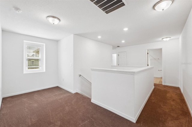 carpeted empty room featuring recessed lighting, visible vents, and baseboards