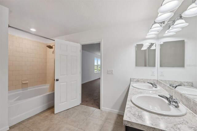 full bath with double vanity, washtub / shower combination, a sink, and tile patterned floors