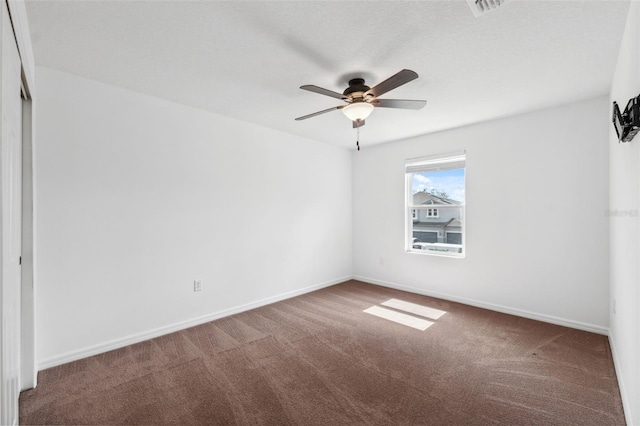 carpeted empty room with ceiling fan and baseboards